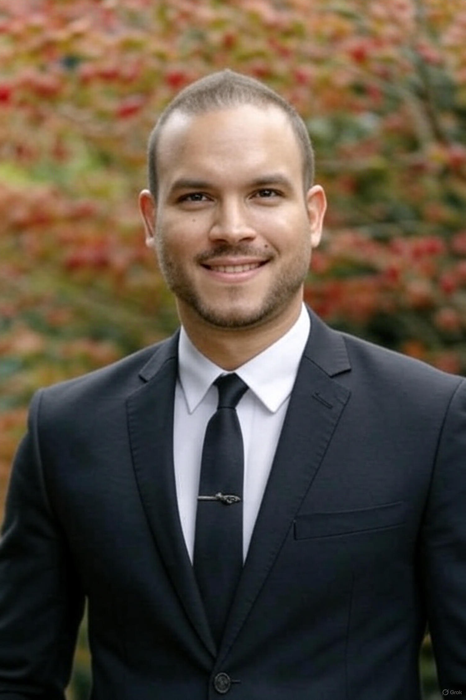 Andre Costa in a dark suit, white shirt, and tie